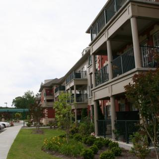 A modern apartment building with balconies and landscaped surroundings.
