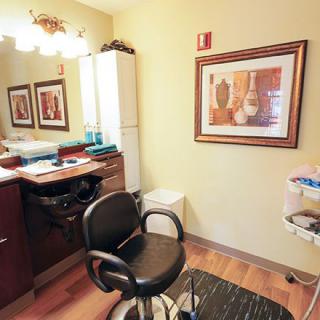 A cozy hair salon interior with a styling chair and mirrors.