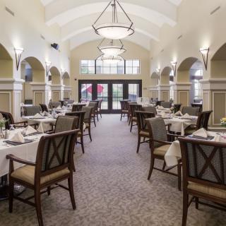 An elegant dining room with neatly arranged tables and soft lighting.