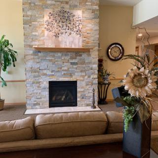 A cozy living room featuring a stylish stone fireplace and comfortable seating.