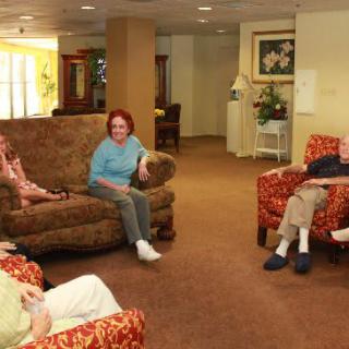A group of seniors sitting in a comfortable lounge area and socializing.