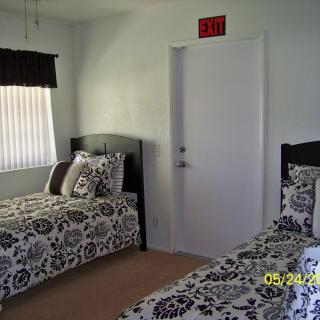 A bedroom with two twin beds featuring black and white patterned bedding.
