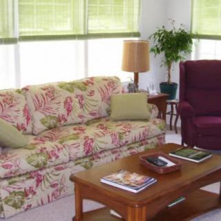 A cozy living room with a floral patterned sofa and a wooden coffee table.