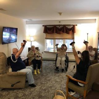 A group of elderly individuals participating in an indoor exercise session.