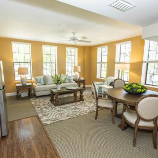 A bright, well-furnished living and dining area with large windows.