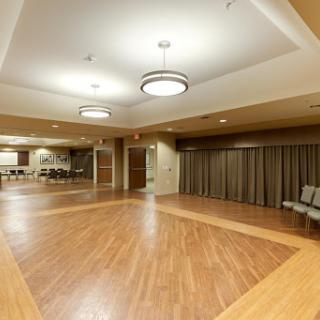 A spacious interior hall designed for events, featuring a wooden floor and modern lighting.