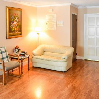 A cozy living room with a sofa, lamp, and a decorative painting on the wall.