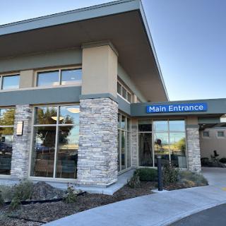A modern office building featuring large windows and a welcoming entrance.
