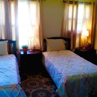 A cozy bedroom with twin beds and soft lighting.