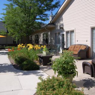 A sunny patio with comfortable furniture and vibrant garden flowers.