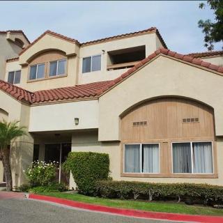 A multi-story residential building with a landscaped exterior and stylish architecture.