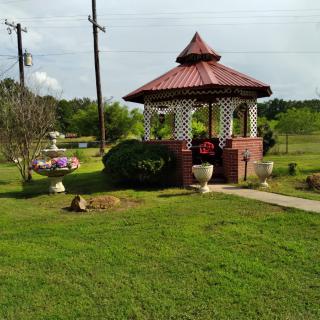A picturesque gazebo surrounded by a well-maintained garden and lush greenery.