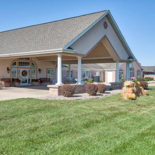 A well-maintained suburban building with a landscaped lawn and covered entrance.