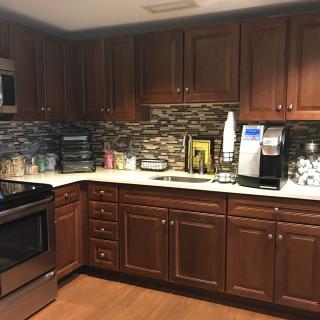 A modern kitchen with wooden cabinets and various appliances.