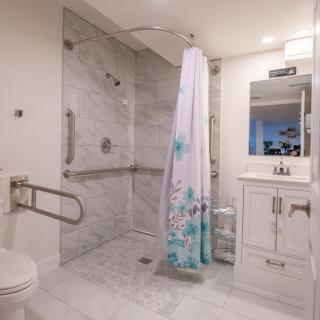 A modern bathroom with a walk-in shower and marble tile design.