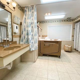 Spacious bathroom with a bathtub, double sink, and bright lighting.