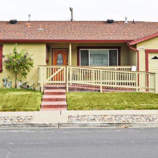 A single-story ranch-style house with a porch and a well-maintained front yard.