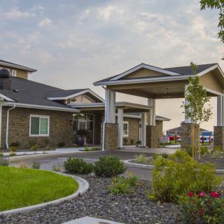 A modern building with a landscaped pathway and covered entrance.