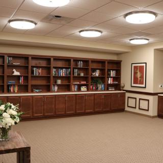 A quiet library space with wooden bookshelves, neatly arranged books, and soft lighting.