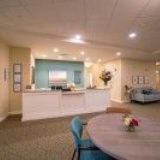 A modern reception area featuring a desk, comfortable seating, and warm lighting.