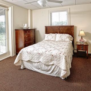 A cozy and well-furnished bedroom featuring a double bed, wooden dresser, and a warm atmosphere.