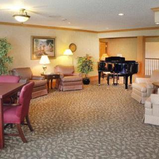 A cozy living room with a grand piano and comfortable seating.