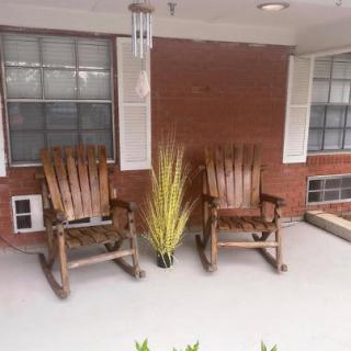 A cozy front porch featuring two wooden rocking chairs and a decorative plant.