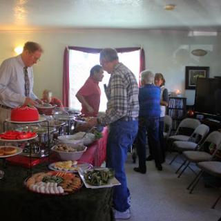 A cheerful gathering with friends enjoying a variety of dishes at a buffet-style setup.