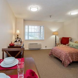 Cozy bedroom with a neatly set dining table and warm lighting.