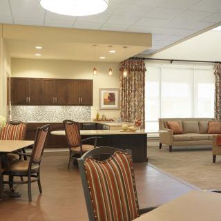 A cozy interior featuring a living room with a sofa, dining area, and kitchen space.