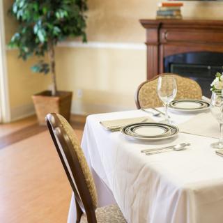 An elegantly set dining table in a restaurant with fine china and glassware.