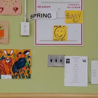 A vibrant display of wall decorations showcasing children's artwork, seasonal themes, and cheerful messages.