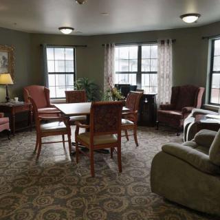 Cozy living room with a table, chairs, and large windows.