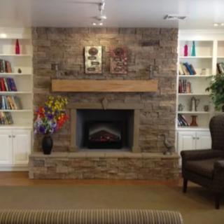 Cozy living room with a stone fireplace and built-in bookshelves.