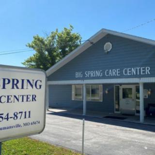 A sunny day view of the Big Spring Care Center with a sign in the foreground.
