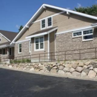 A residential house with a stone facade and a sloped driveway.