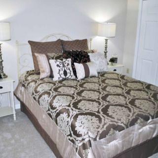 A stylishly decorated bedroom with patterned bedding and elegant lamps.
