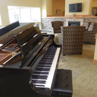 A cozy living room featuring a grand piano and comfortable seating.