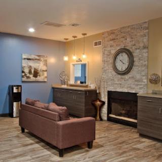 A stylish living room featuring modern furniture, a cozy fireplace, and artistic wall decor.