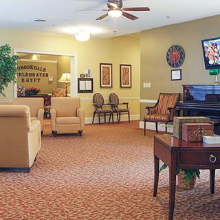 A welcoming lobby area featuring comfortable seating, a television, and a piano.