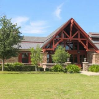 A beautiful house with a brick exterior and landscaped lawn under a clear blue sky.