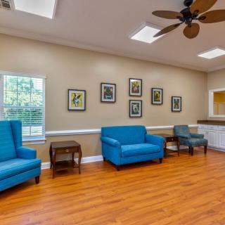 A cozy waiting room with blue chairs and wooden flooring.