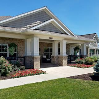 A charming residential building featuring a welcoming front porch and well-maintained landscaping.
