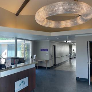 A bright and modern hospital reception area with a stylish chandelier.