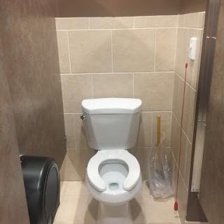 A clean restroom featuring a standard toilet and tiled walls.