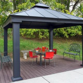 An outdoor gazebo with a dining set, featuring a table and red chairs on a wooden deck.
