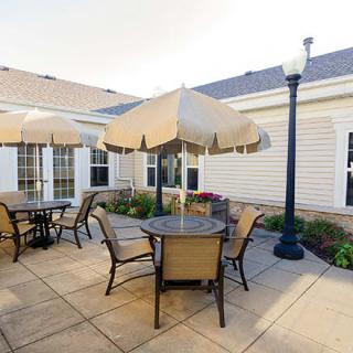 A cozy patio area with tables, chairs, and umbrellas, ideal for outdoor relaxation.