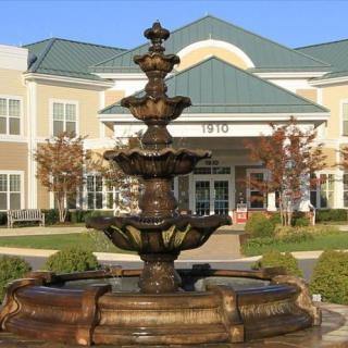 A decorative fountain in front of a modern building.
