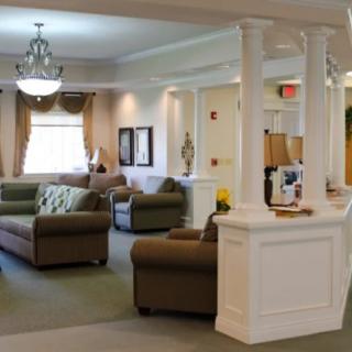 A spacious living room with elegant furniture and decorative pillars.