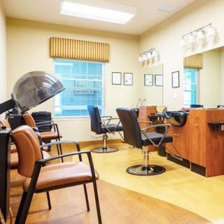 A tidy and well-lit hair salon interior with chairs, mirrors, and a hair dryer.